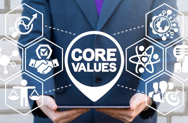 Core Value Business Information Technology concept. Businessman using tablet computer with core values text icon on a virtual screen.